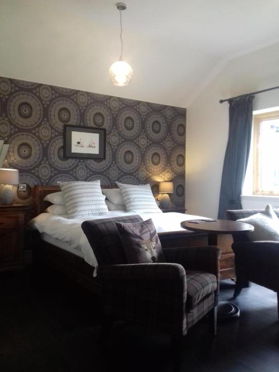 a bedroom with a bed and a couch and a table at 40 Bernisdale - The Sabhal in Skeabost