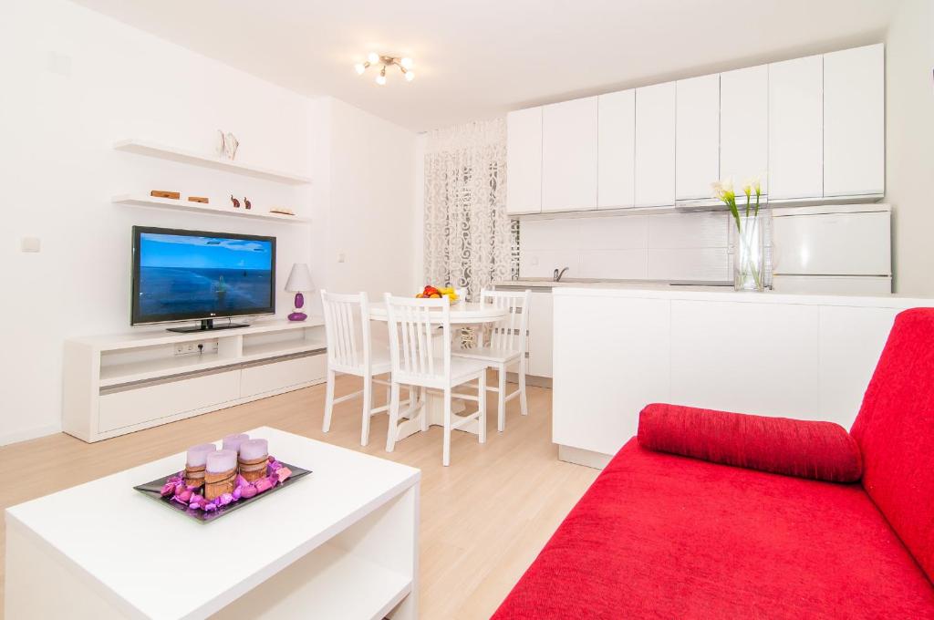 sala de estar con sofá rojo y mesa en Avenue Apartment, en Dubrovnik