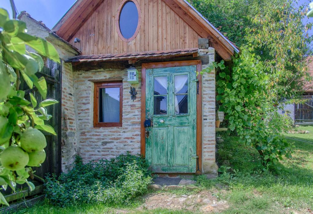 an old brick house with a green door at Dominic Boutique - Atelier in Cloaşterf