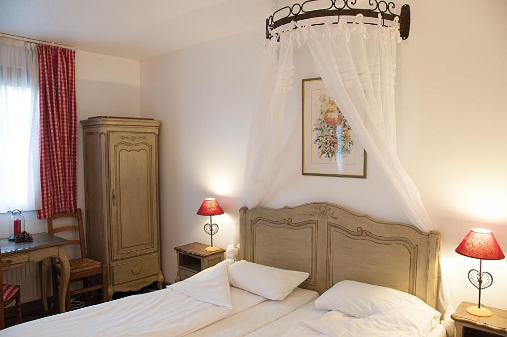 a bedroom with a bed with a canopy at The Originals Boutique, Hôtel La Ferme du Pape, Eguisheim in Eguisheim