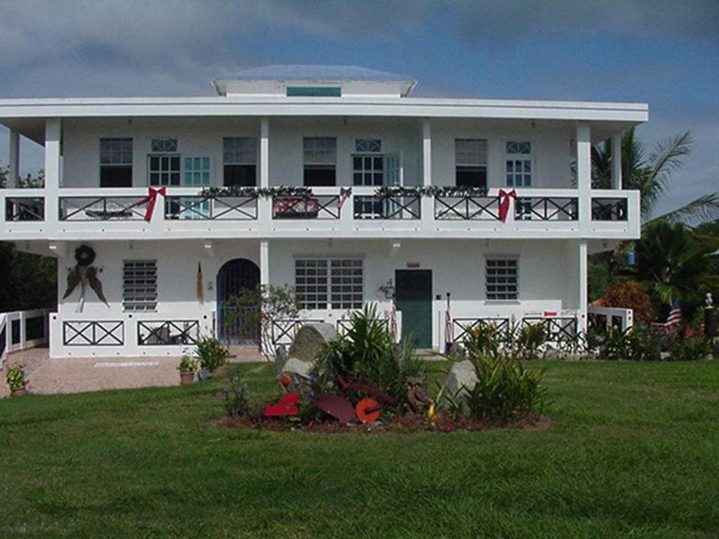 uma casa branca com uma varanda e um quintal em Great Escape and Breakfast Inn em Vieques