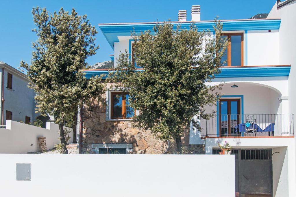 a house with two trees in front of it at Casa Mediterraneo in Cala Gonone
