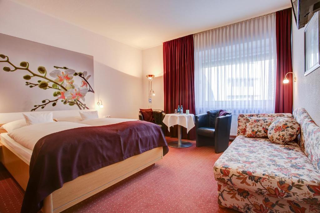 ein Hotelzimmer mit einem Bett und einem Sofa in der Unterkunft INA Hotel Consul in Kiel