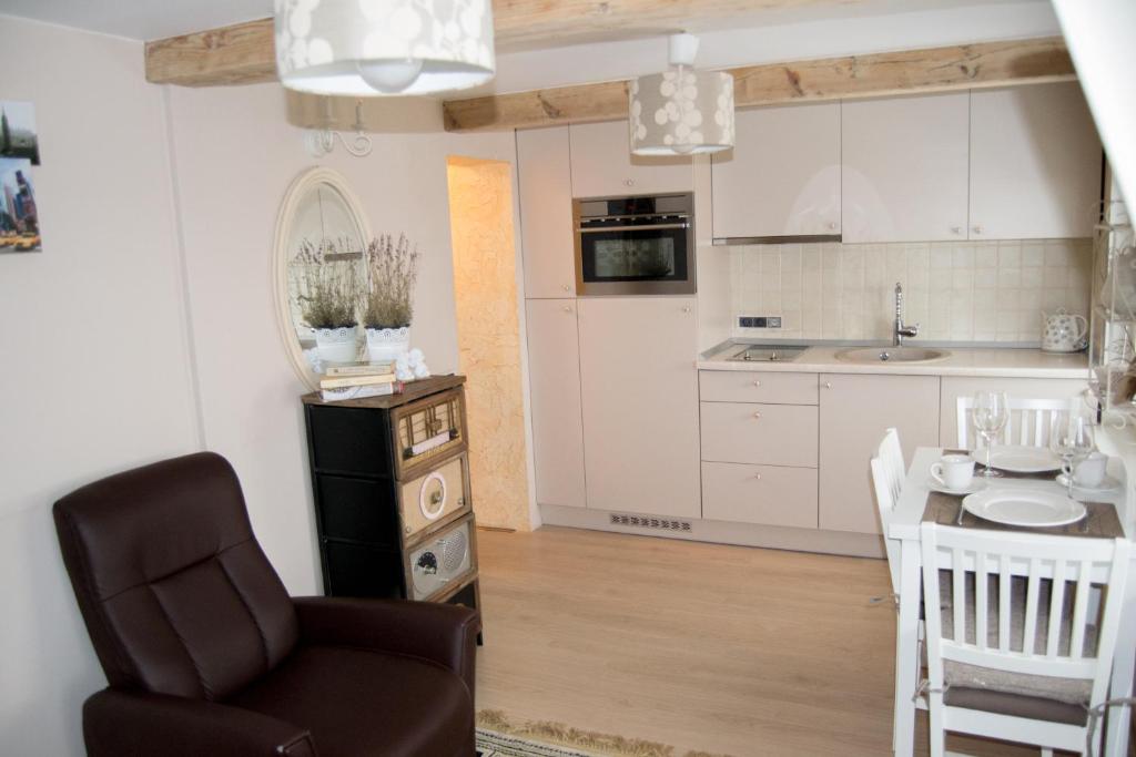 cocina y comedor con silla y mesa en Skruzdynės Apartamentai, en Nida