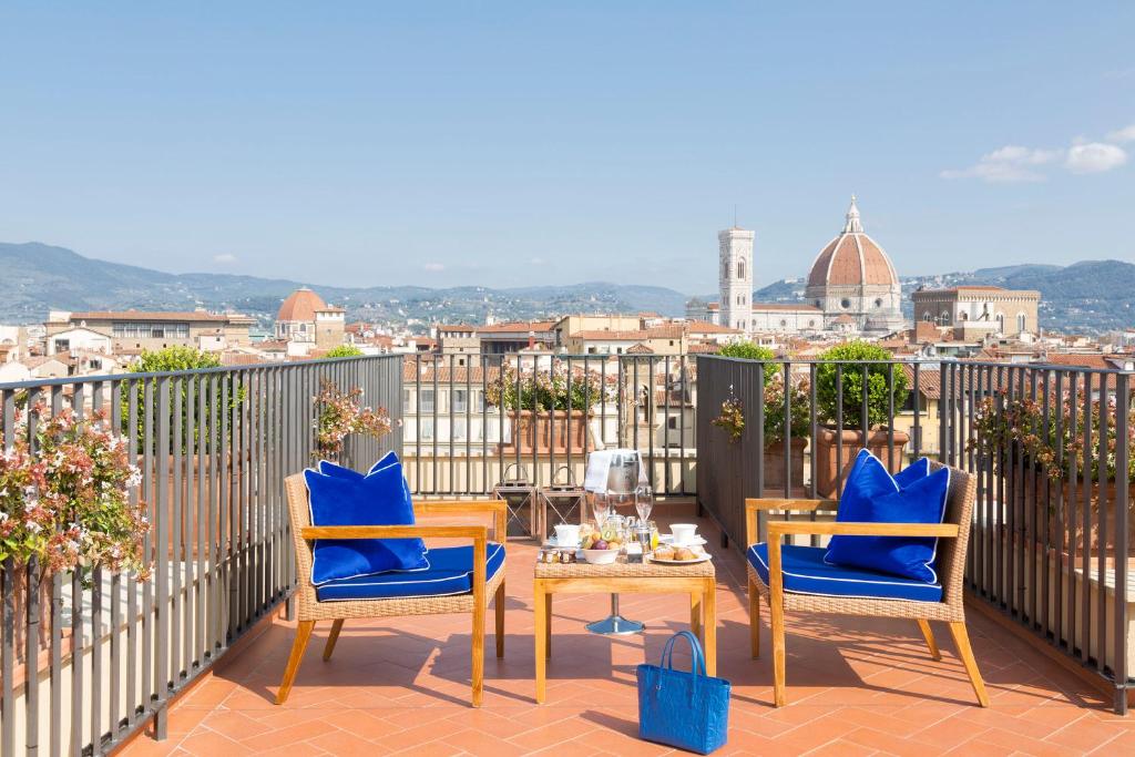 a patio area with chairs, tables, and umbrellas at Hotel Lungarno - Lungarno Collection in Florence