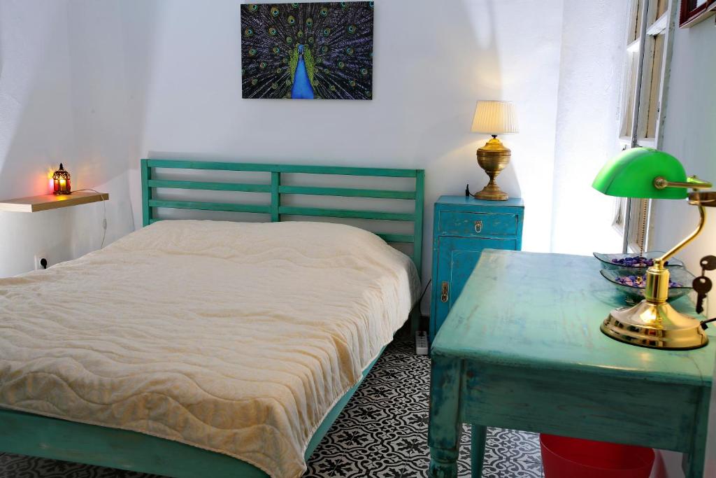 a bedroom with a bed and a table with a lamp at Vintage 1930's flat in the center of Thessaloniki in Thessaloniki