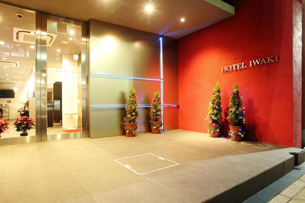 Hotel Iwaki في إيواكي: واجهة متجر وأشجار عيد الميلاد أمام متجر