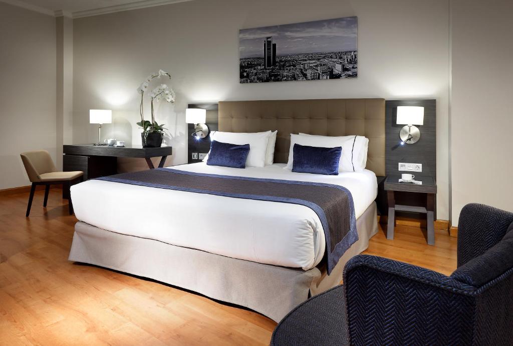 トレス・カントスにあるEurostars Madrid Foroのベッドルーム1室(大型ベッド1台、椅子2脚付)