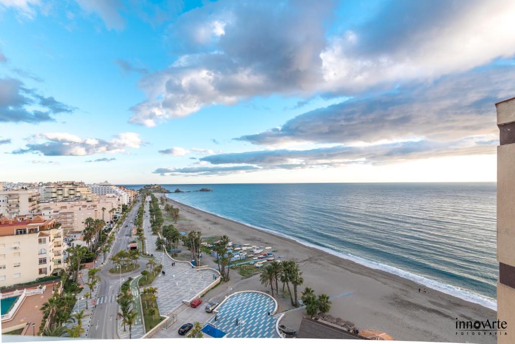 vistas a una playa con palmeras y al océano en Apartamentos Chinasol, en Almuñécar