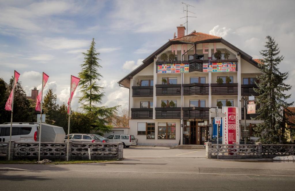 a large building with flags in front of it at Hotel Krona Domžale in Domžale
