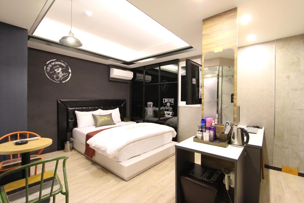 a bedroom with a bed and a desk with a phone at Line Motel in Daegu