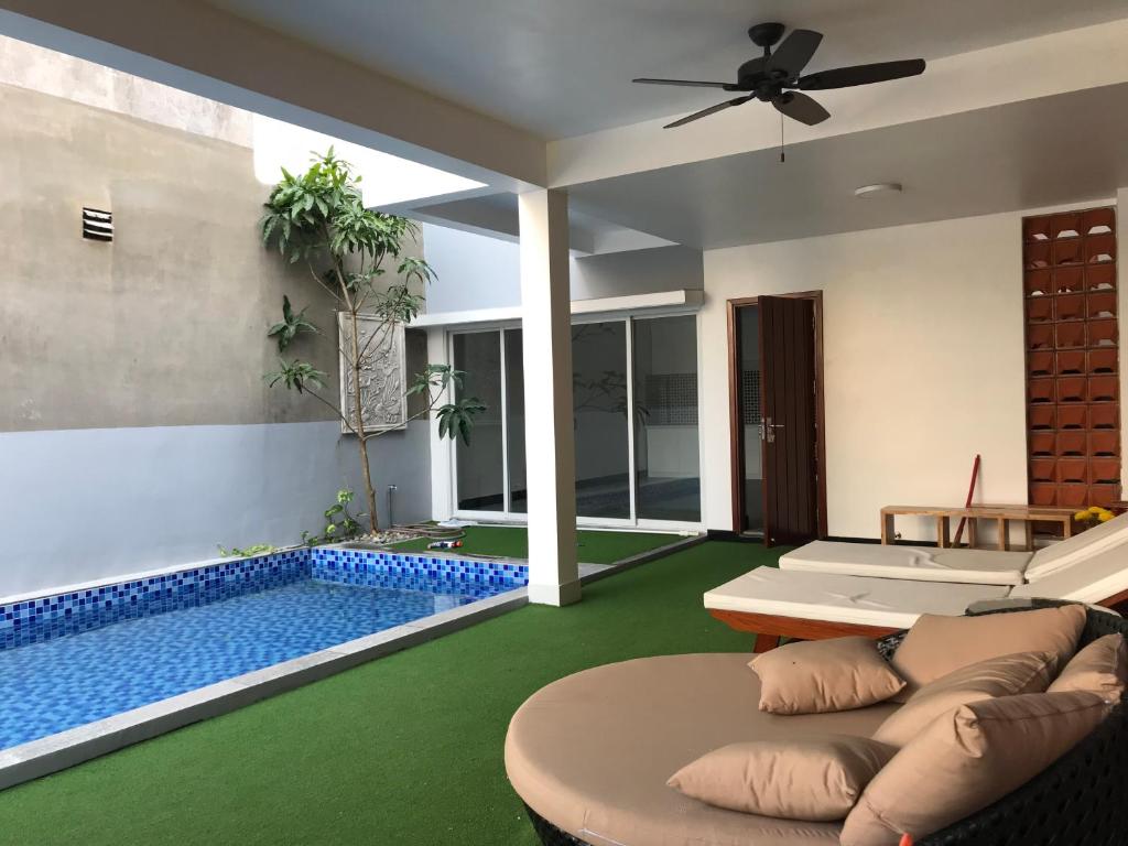a living room with a pool and a ceiling fan at Pho Bien Homestay in Phan Thiet