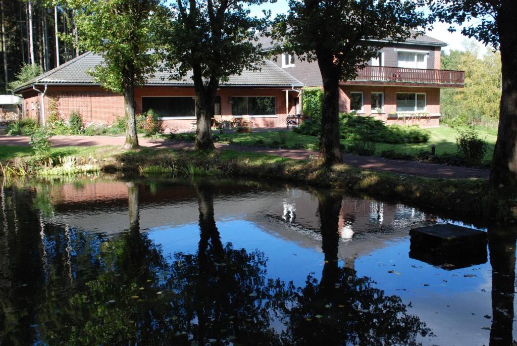 a house with a pond in front of a house at B&B Het Groote Genoegen in Manderfeld