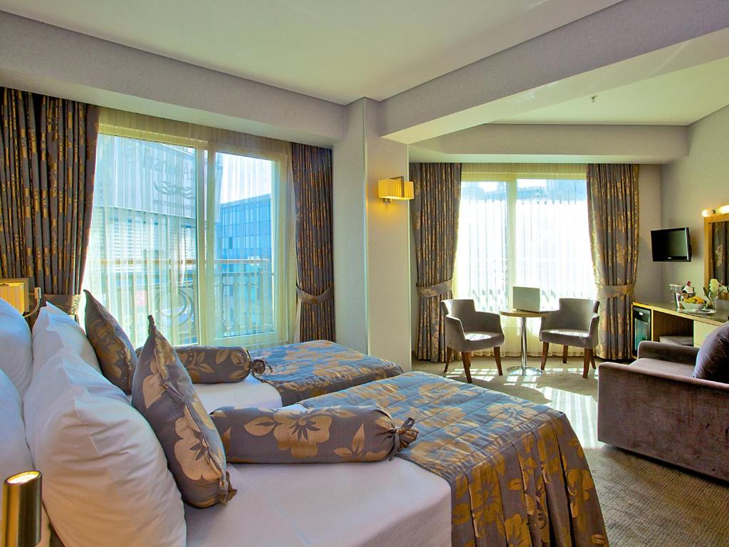 イスタンブールにあるHotel Momento - Special Categoryのベッド2台とリビングルームが備わるホテルルームです。