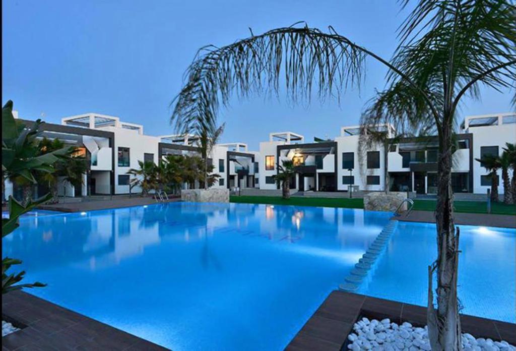 a large swimming pool in front of a building at OasisBeach Penthousse la Zénia in Playas de Orihuela