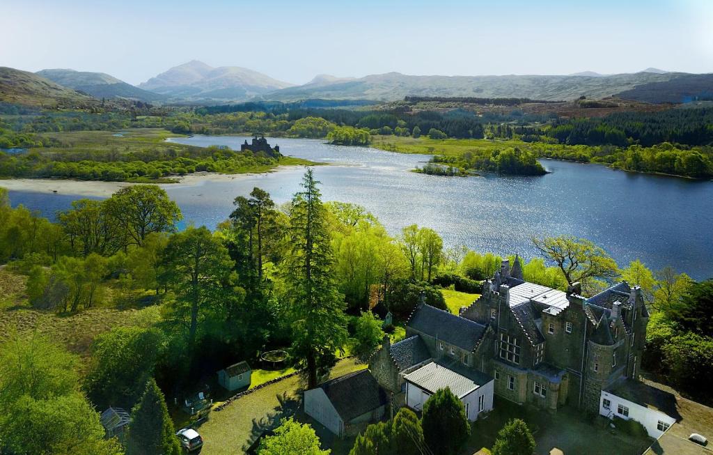 an aerial view of a castle and a lake at Kilchurn Suites in Loch Awe