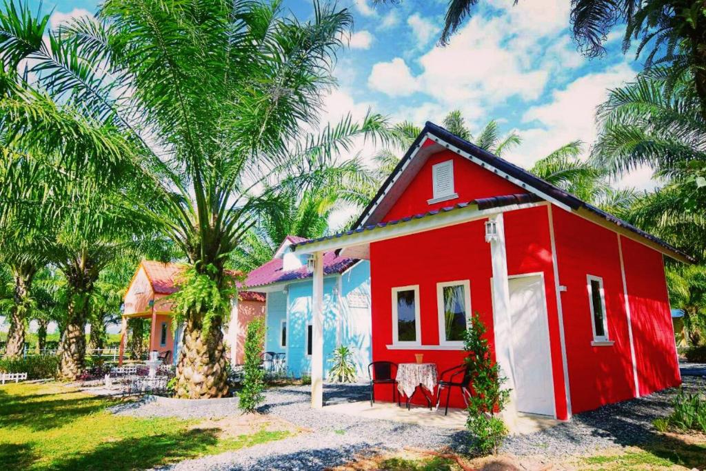 a red and white house with a palm tree at View Dao Jantra in Chachoengsao