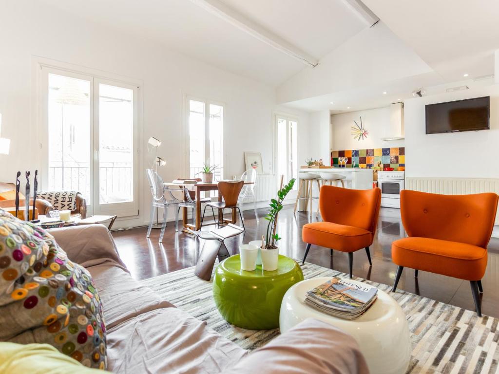 マルセイユにあるWelkeys Apartment - Sainteのリビングルーム(ソファ、オレンジの椅子付)