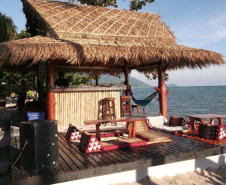 une cabane sur la plage avec des chaises et une table dans l'établissement Coco Garden Resort, à Thongsala