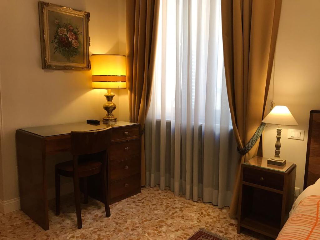 ローマにあるNori Guest Houseのベッドルーム(ランプ付きのデスク、窓付)