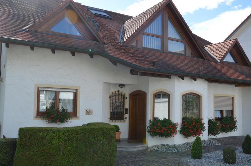 uma casa branca com um telhado castanho em Privatzimmer Ulbricht/Föhr em Friedrichshafen