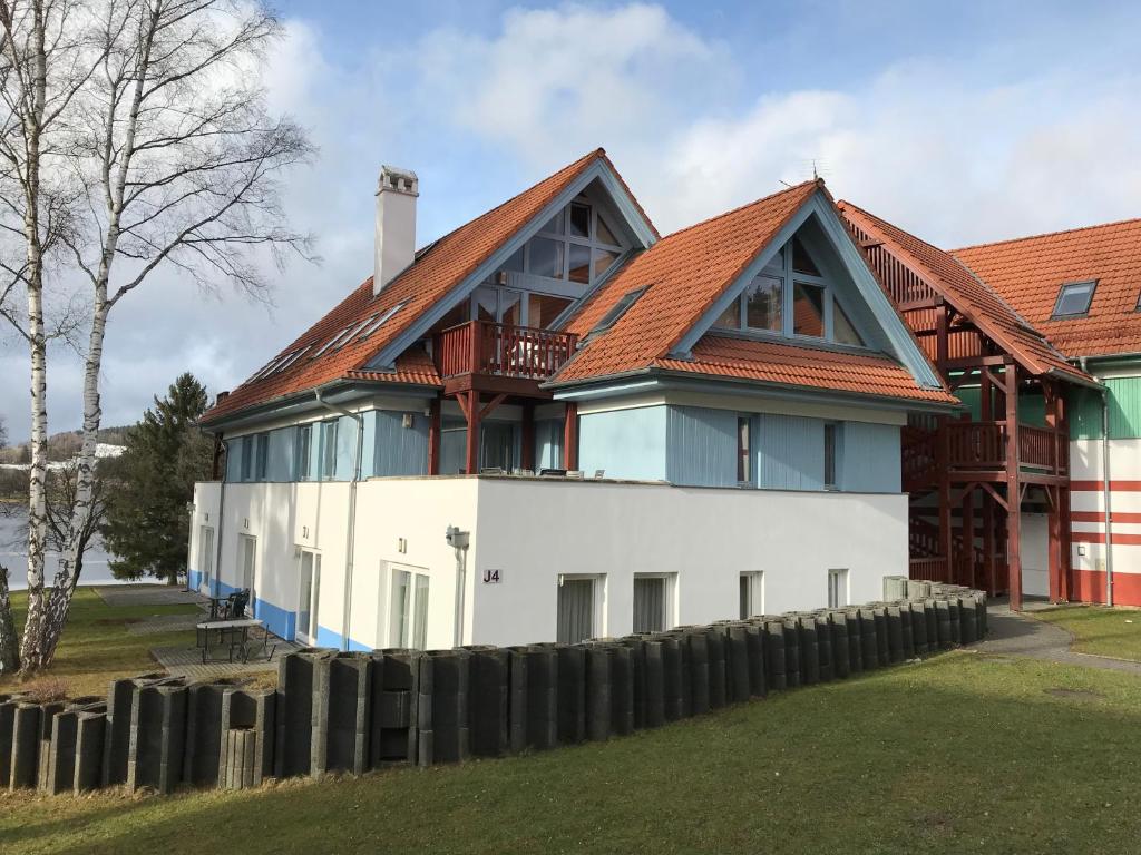 ein großes weißes Haus mit rotem Dach in der Unterkunft Riviera Lipno 415 in Lipno nad Vltavou