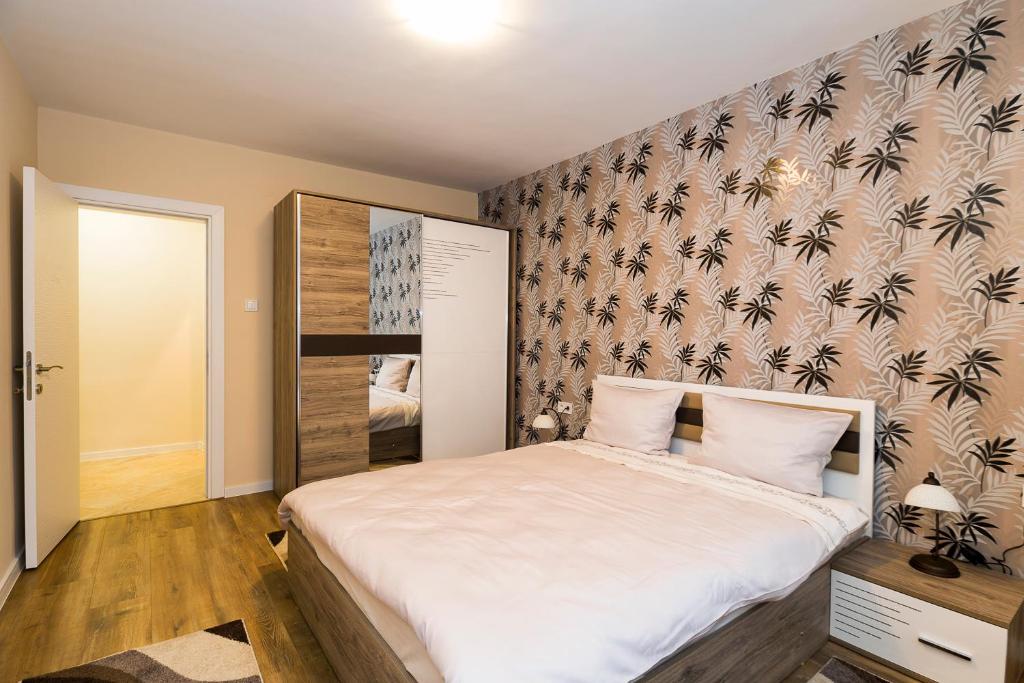 een slaapkamer met een groot wit bed met een muur bij Guest apartment "Perunika" in Plovdiv