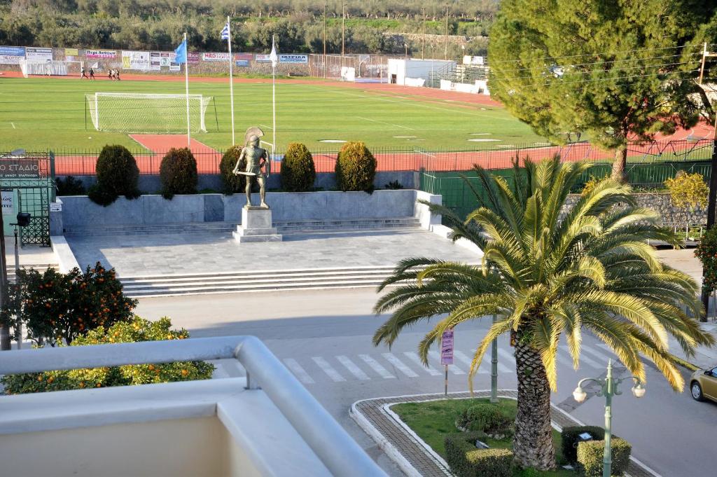 une statue devant un stade avec un terrain de football dans l'établissement Laconian Collection Leonidas, à Sparte
