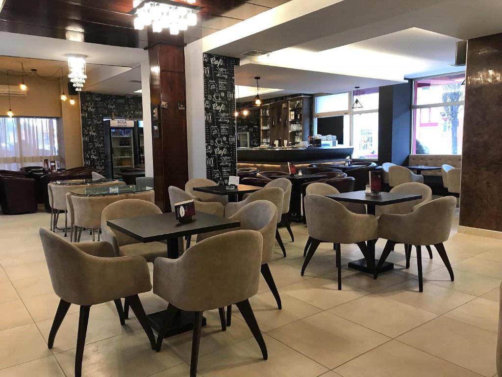 un ristorante con tavoli, sedie e pianoforte di Golden Inn Hotel a Majdanpek