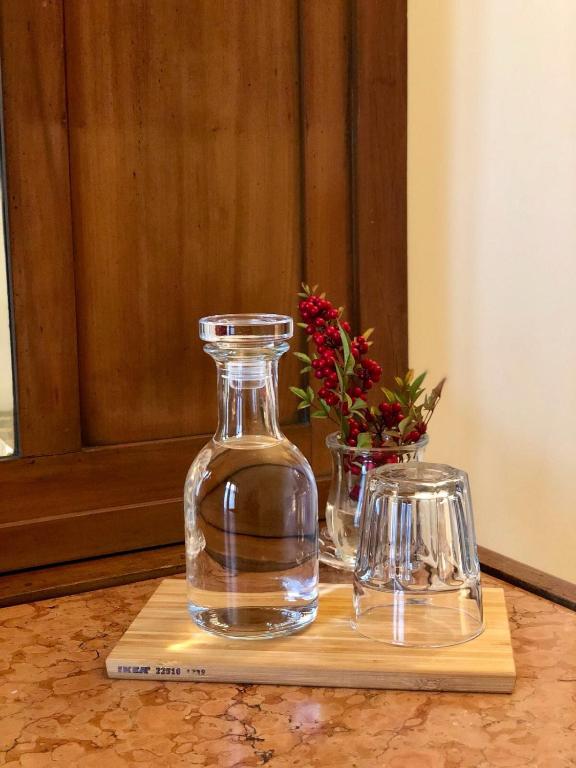 a glass bottle and two vases on a cutting board at Cascina Gaggioli in Milan