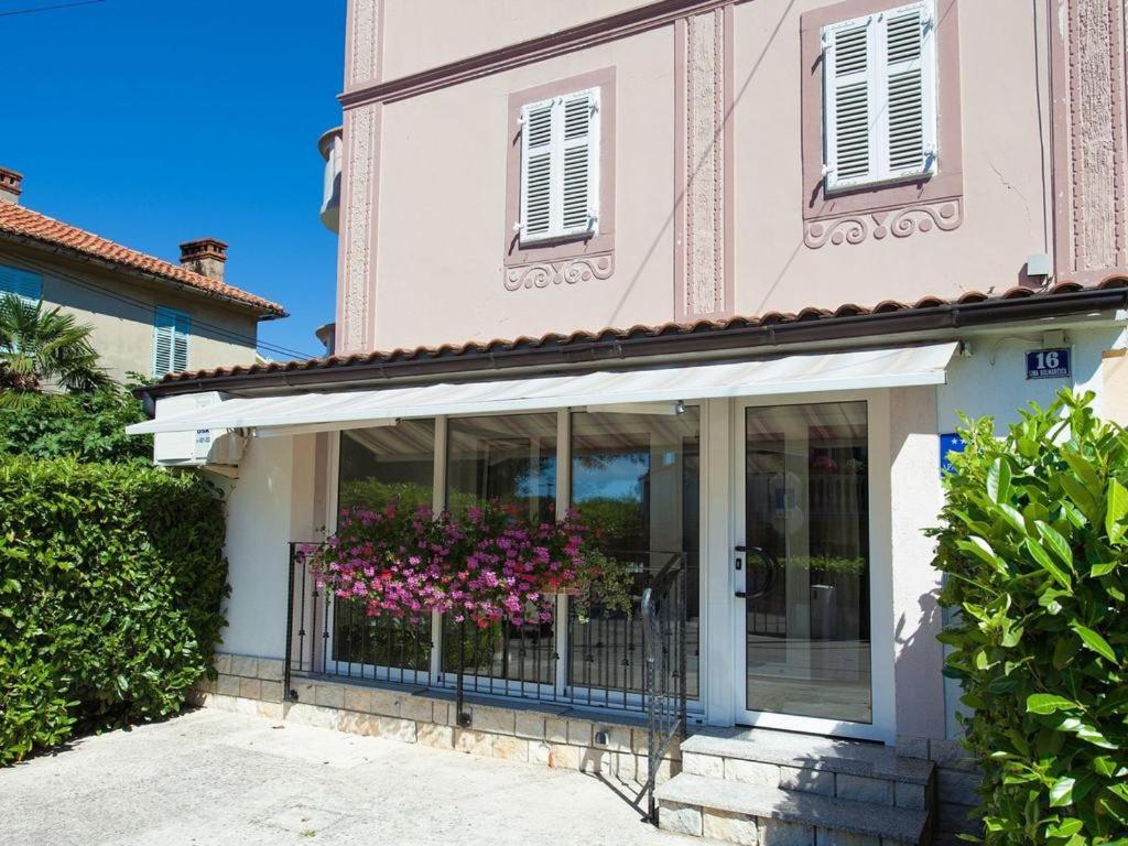 a house with a balcony with flowers on it at More in Malinska