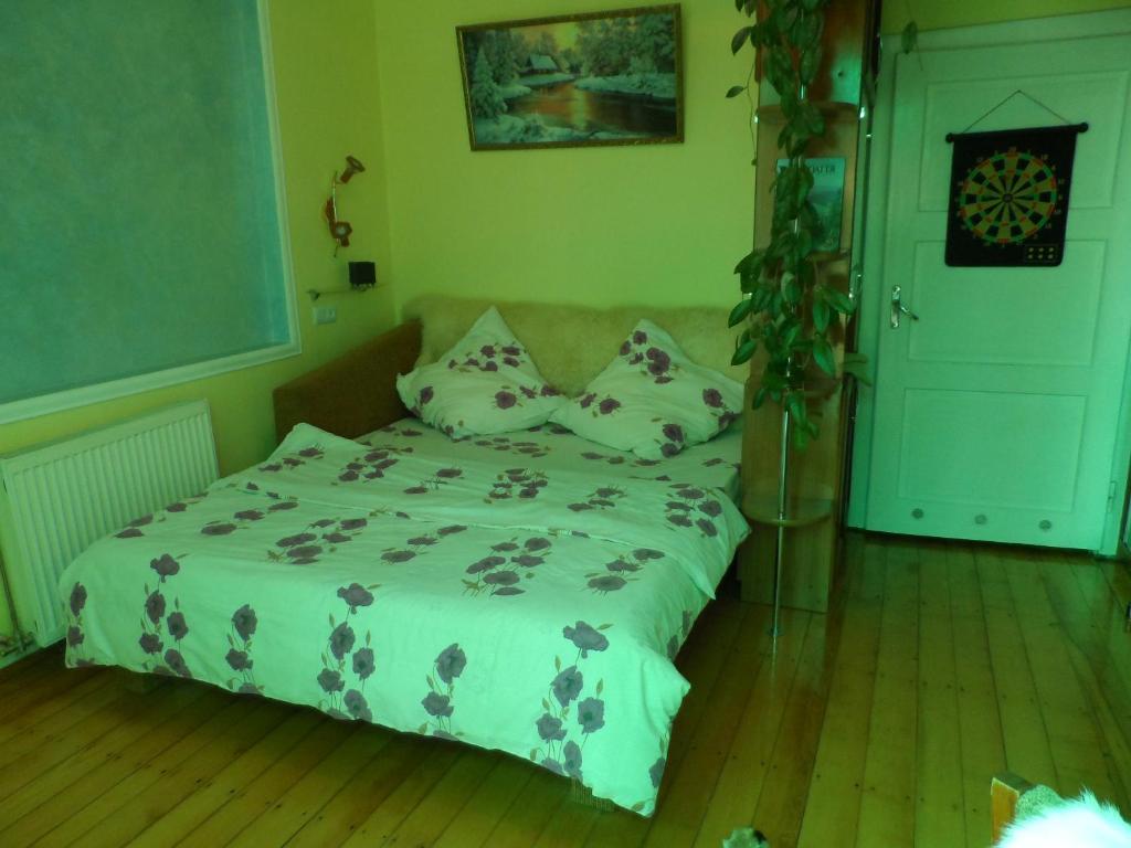 a bedroom with a bed with pillows on it at "Ранчо" - тераса квіти сад басейн in Uzhhorod