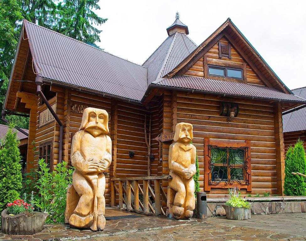 two large bear statues in front of a log cabin at Na Penkah in Yaremche