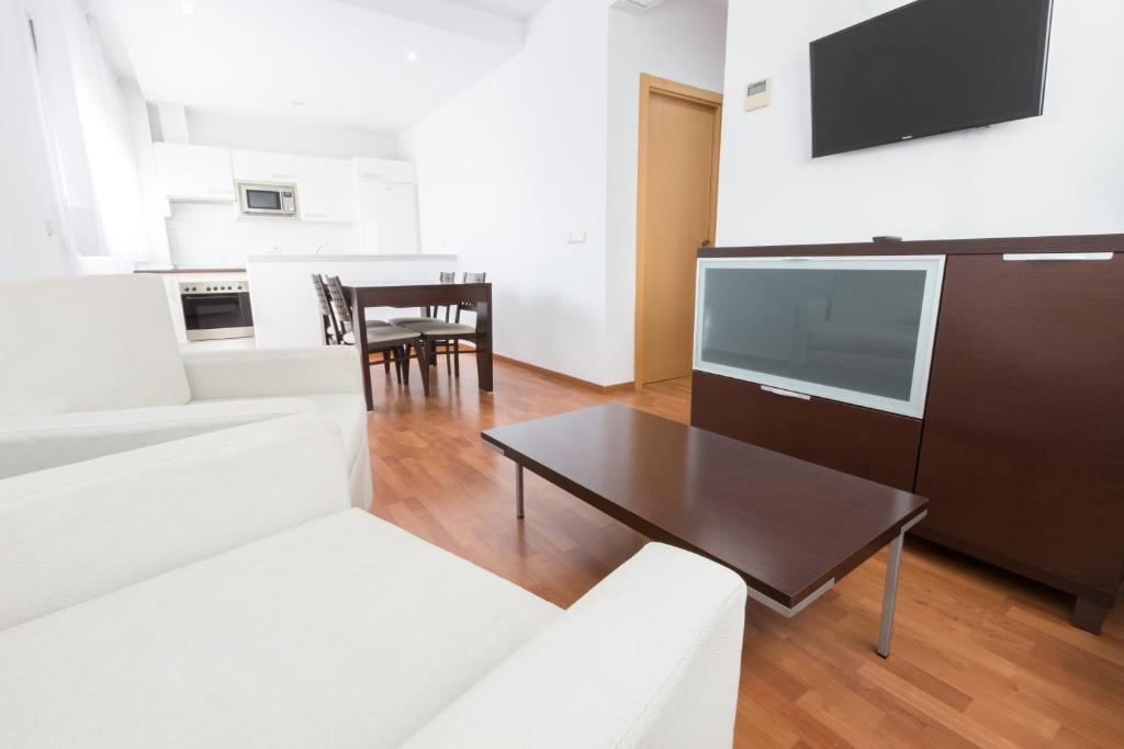 - un salon avec un canapé et une table dans l'établissement Domocenter Apartamentos Turísticos, à Bormujos