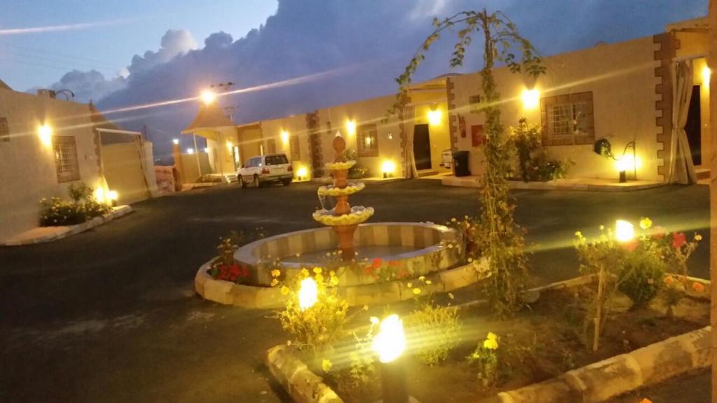 a fountain in the middle of a courtyard at night at Taraf Al Asalah Villas in An Nimāş