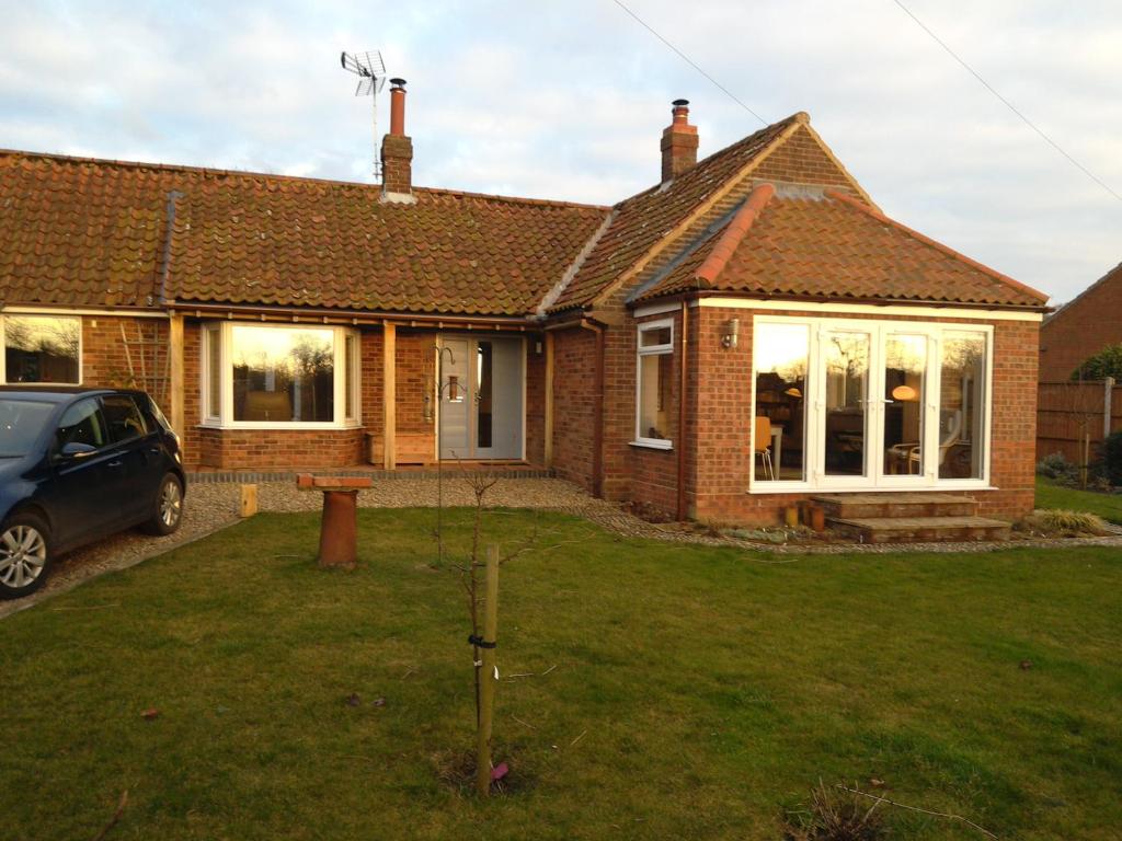 a house with a car parked in front of it at The Old Wash House in Fakenham