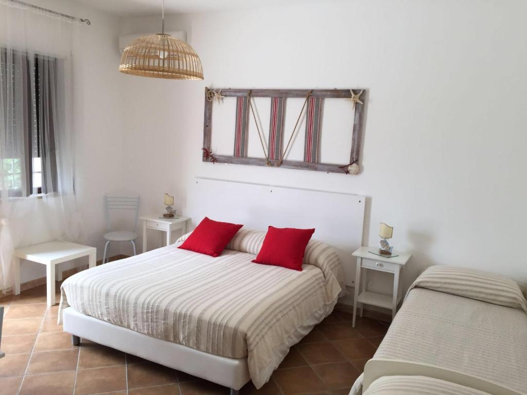 1 dormitorio con 2 camas y almohadas rojas en Nonna Pina en Torre Canne