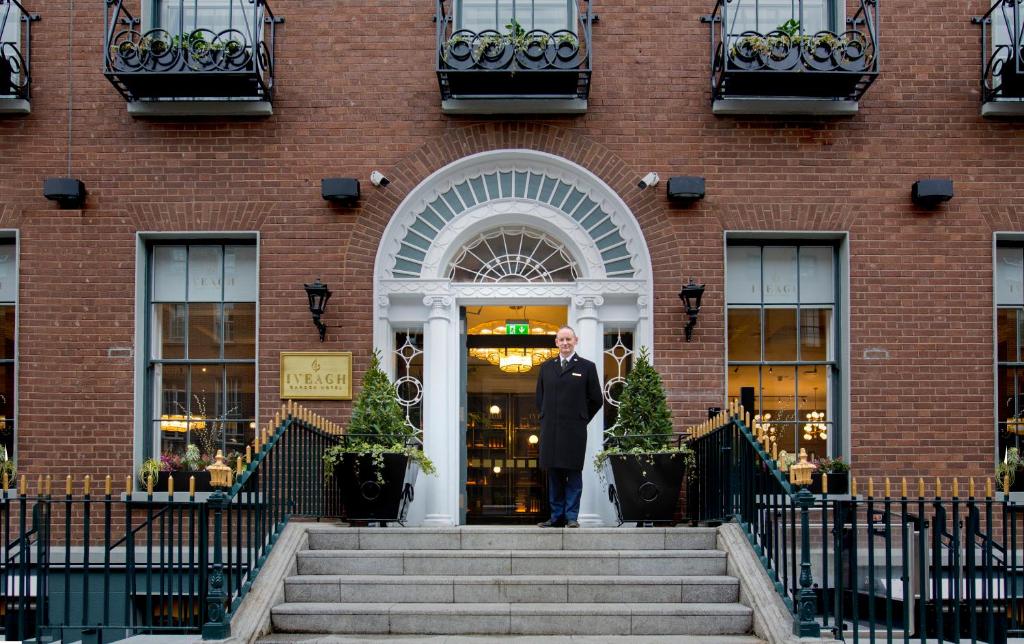 un homme debout devant un bâtiment dans l'établissement Iveagh Garden Hotel, à Dublin