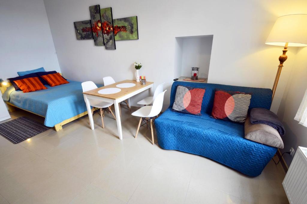 - un salon avec un canapé bleu et une table dans l'établissement Studio Aleja 77, à Częstochowa