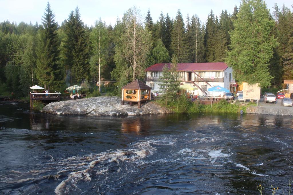 a house on a rock in the middle of a river at Tsar Gory Guest House in Ruskeala