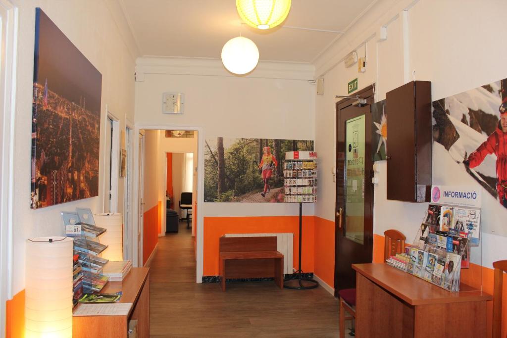 um corredor de uma loja com paredes laranja e branca em Pensión Arosa em Barcelona