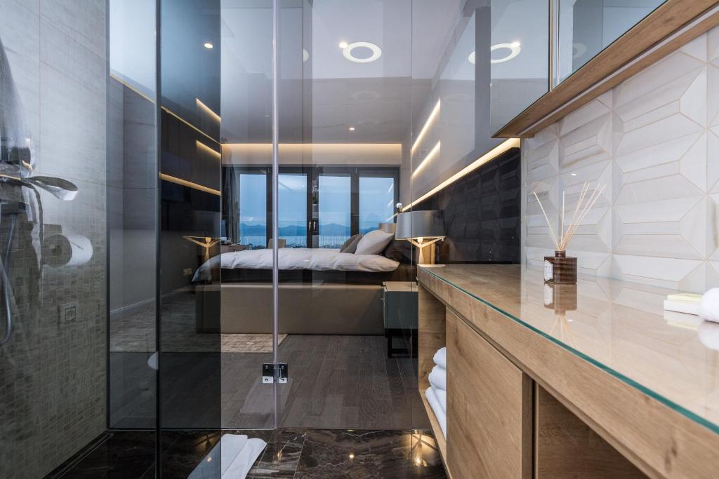 główna sypialnia z łóżkiem i szklaną ścianą w obiekcie Luxury Apartment Kortina w mieście Zadar