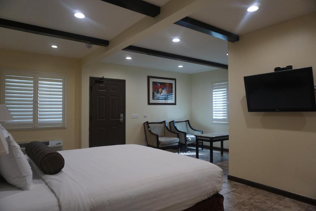1 dormitorio con 1 cama y TV de pantalla plana en Tuscan Garden Inn en Los Ángeles