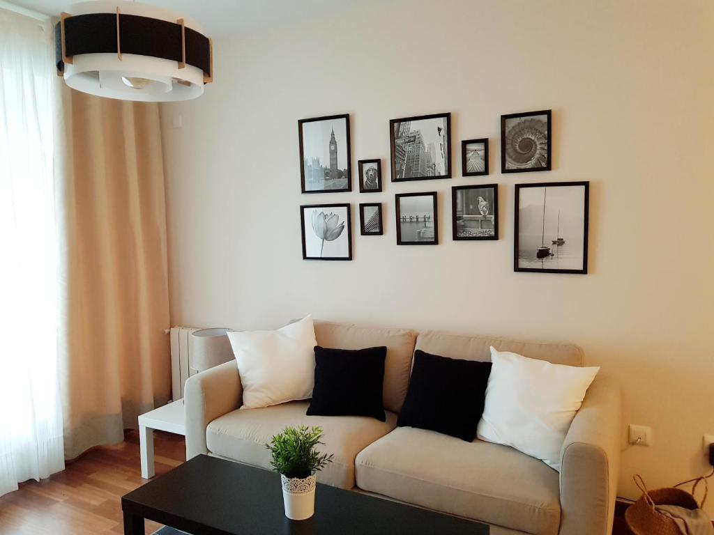 uma sala de estar com um sofá e quadros na parede em River Park Valencia em Valência