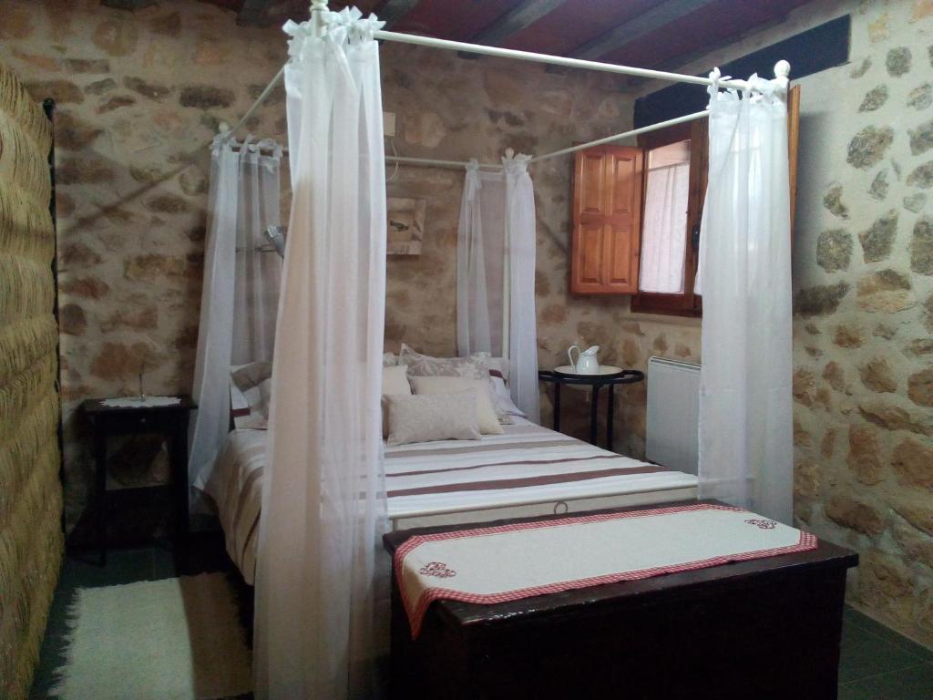 Schlafzimmer mit Himmelbett und Vorhängen in der Unterkunft Casa De Vacances La Vella Era in Arnés