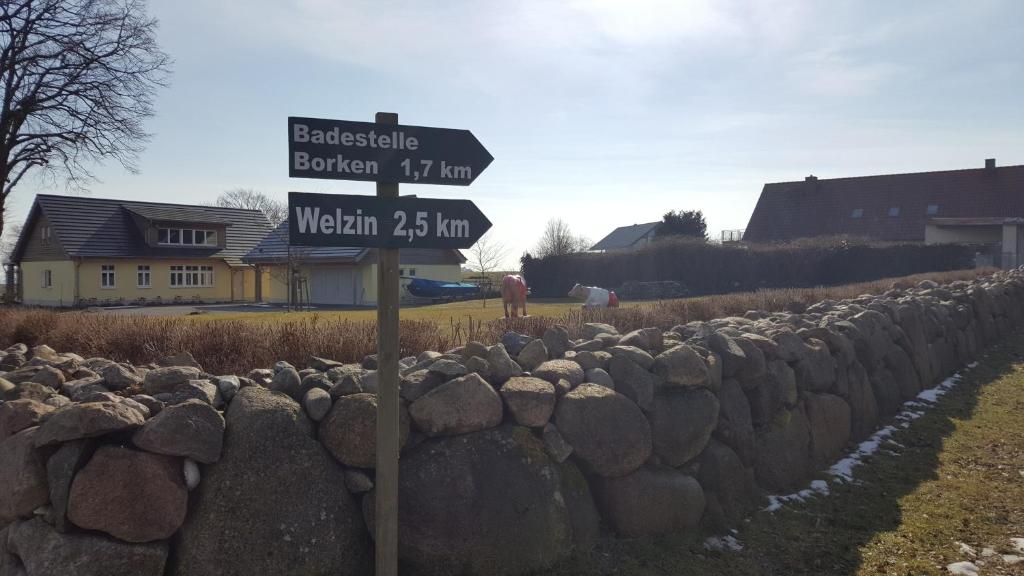 a street sign in front of a stone wall at Kleine Auszeit in Stolpe auf Usedom