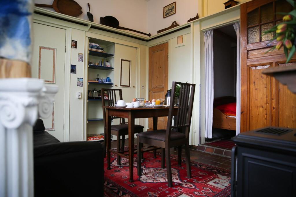 een eetkamer met een tafel en 2 stoelen bij B&B Gasthuis 288 in Delft