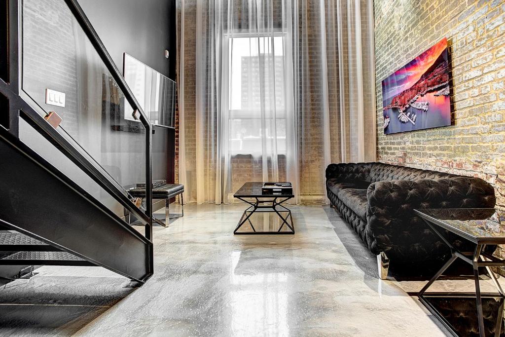 a living room with a couch and a brick wall at Boutique Lofts Milton Parc by Simplissimmo in Montreal