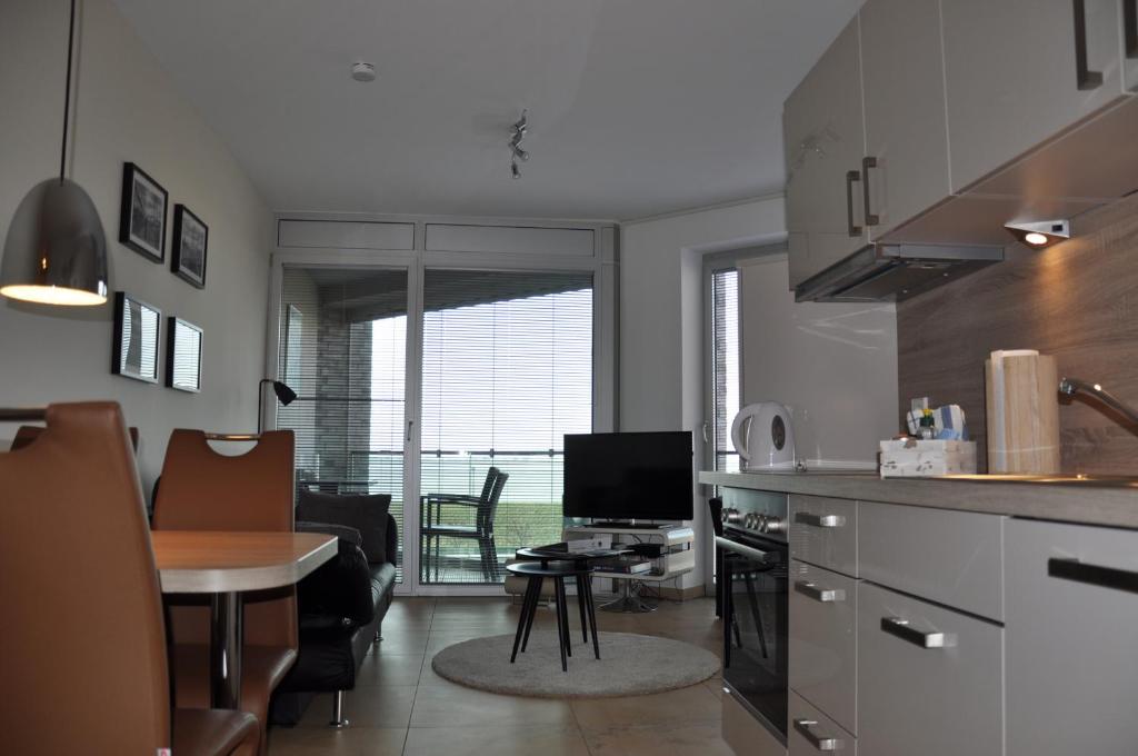 a kitchen and living room with a table and chairs at Am Neuen Hafen in Bremerhaven
