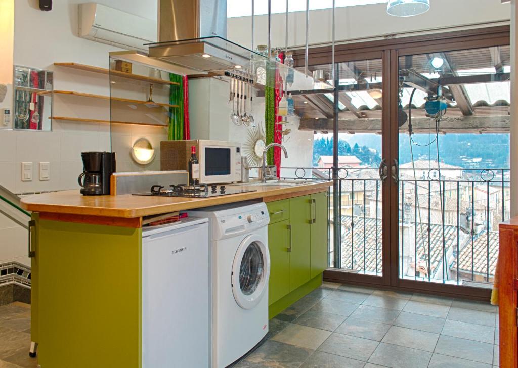a kitchen with a washing machine and a balcony at Studio avec vue panoramique in Puget-Théniers
